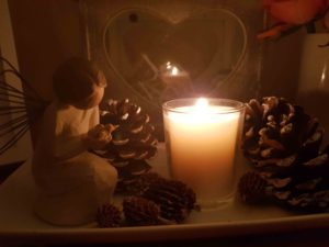 Candle fir cones and small statue praying